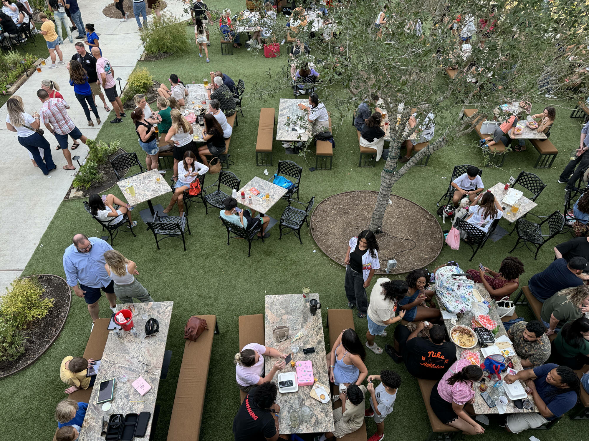 The beer garden lawn full of people at tables