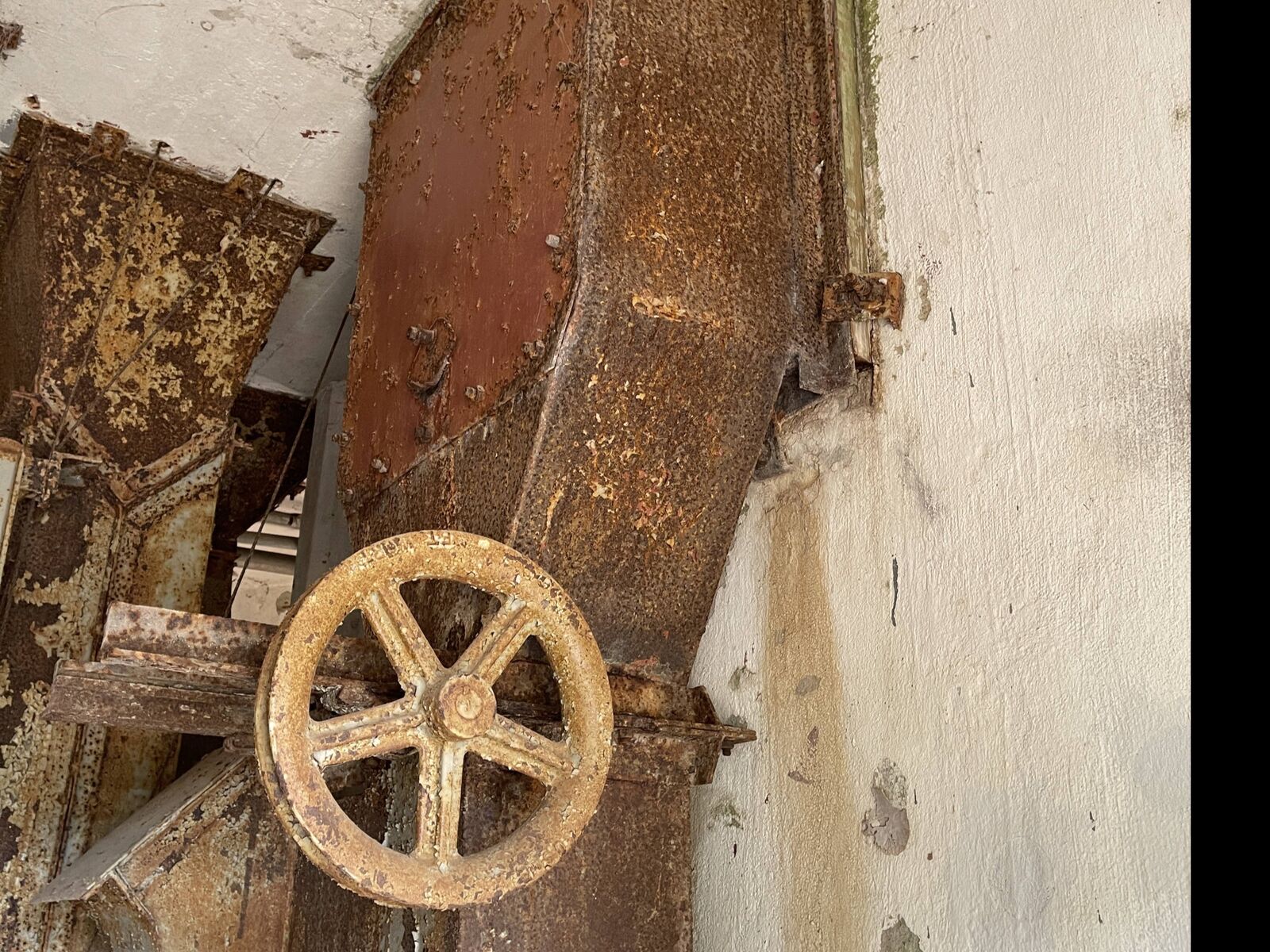 Rusted wheels and gears of the old drying machinery inside the dryer