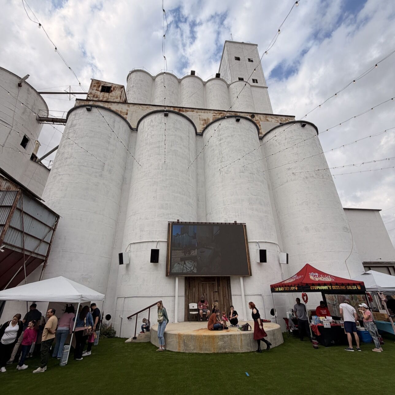 Market tents and visitors at the foot of the silos